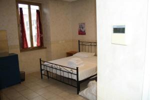 a small bedroom with a bed with white sheets at Casa Vacanze Il Conservatorio - by Be Your Home in Civitavecchia
