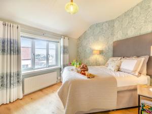 Un dormitorio con una cama grande y una ventana en Oak Cottage en Saxmundham