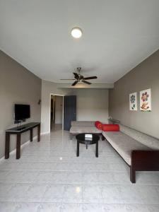 a living room with a couch and a ceiling fan at Perdana Serviced Apartment & Resorts in Kampung Padang Masirat