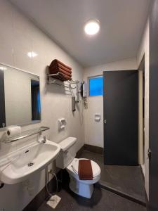 y baño con aseo blanco y lavamanos. en Perdana Serviced Apartment & Resorts en Kampung Padang Masirat