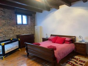 1 dormitorio con 1 cama grande con almohadas rojas en Al vecchio fienile en Fagagna