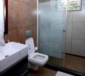 a bathroom with a toilet and a glass shower at EV StayZ in Cherai Beach