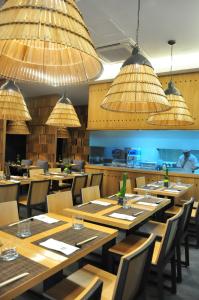 a restaurant with wooden tables and chairs and chandeliers at Astoria Plaza in Manila