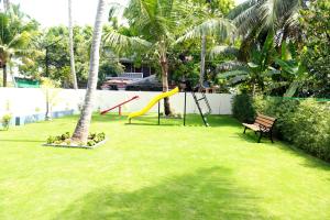 a park with a playground with a slide and a bench at EV StayZ in Cherai Beach