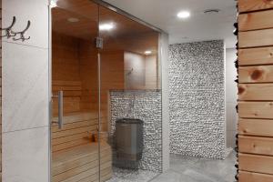 a glass shower in a bathroom with a trash can at Apartamenty Szuflandia in Wisła