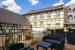 uma varanda com cadeiras e um edifício amarelo em Hotel Schwan em Oestrich-Winkel