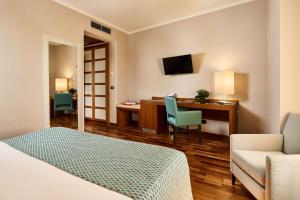 a hotel room with a bed and a desk and a couch at Hotel Da Vinci in Vinci