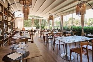 a restaurant with tables and chairs and windows at Hotel Da Vinci in Vinci
