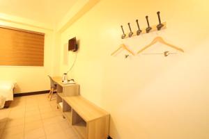 a room with a bench and a table and a bed at Leo Hotel - Lifestrong Property Inc in Baguio