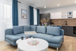 コウォブジェクにあるBaltic Marina Residence Apartments by Noclegi Rentersの青いソファとテーブルのあるリビングルーム