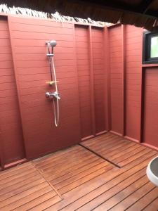 y baño con pared roja y ducha. en Bann Pae Cabana Hotel And Resort, en Klaeng