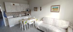 een woonkamer met een bank en een tafel en een keuken bij Valdisieve Guest House Appartamento 20 minuti da Firenze in Pontassieve
