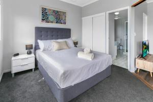 a bedroom with a large bed and a bathroom at Unit 41 at Portobello Dicky Beach in Caloundra