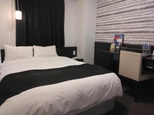 浜松市にあるアパホテル〈浜松駅南〉のベッドルーム(白い大型ベッド1台、デスク付)