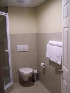 a small bathroom with a toilet and towels at Regal Inn PMBurg in Pietermaritzburg