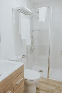 bagno bianco con servizi igienici e doccia di Texeda Room Suites a Tejeda