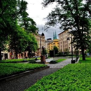 a city street with buildings and a park with trees at Hostel Diana Park in Helsinki