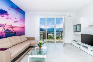 een woonkamer met een bank en een tv bij Four Seasons Apartments in Kotor