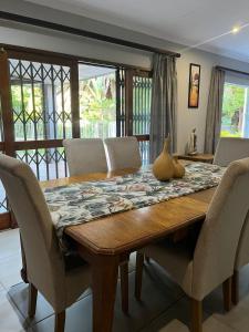 a dining room table with chairs and a vase on it at Rosa on St James in Johannesburg