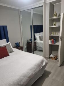 a bedroom with a white bed and a mirror at Rosa on St James in Johannesburg