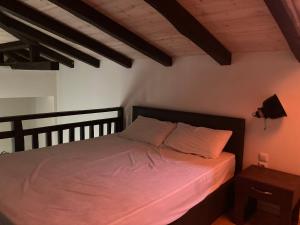 Schlafzimmer mit einem Bett mit rosa Bettwäsche in der Unterkunft KoNaKaRi Garden in Stavros