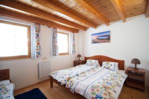 a bedroom with a bed and two windows at Holiday Home Tatralandia in Liptovský Mikuláš