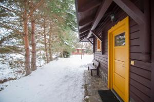 una puerta amarilla en el lateral de un edificio en la nieve en Holiday Home Tatralandia en Liptovský Mikuláš