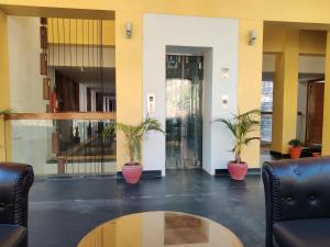 a lobby with two potted plants and a table at Wood Creek Resort & Spa Kasauli in Kasauli