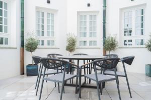 una mesa y sillas en un patio con ventanas en Suites Chinitas, en Málaga