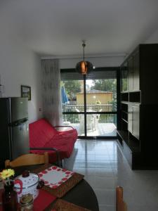 a living room with a red couch and a table at Homely flat with balcony and swimming pool in Bibione