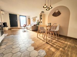 een woonkamer met een tafel en stoelen bij Cocon Nature Montpellier - Jacuzzi & Sauna - 300m du Tramway in Castelnau-le-Lez