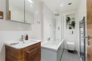 Baño blanco con lavabo y aseo en Stay Hyde Park, en Londres