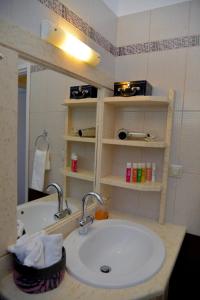 een badkamer met een wastafel en een aanrecht met een spiegel bij Ef Zin Villa by Corfuescapes in Sidari