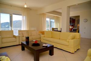 a living room with two yellow couches and a table at Ef Zin Villa by Corfuescapes in Sidari