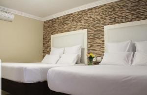 duas camas sentadas uma ao lado da outra num quarto em Bayside Hotel Pinetown em Pinetown