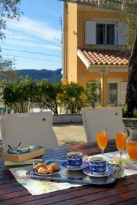 een tafel met een dienblad met eten en glazen sinaasappelsap bij Ef Zin Villa by Corfuescapes in Sidari