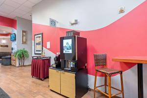 una habitación con una pared roja y un bar en Ramada by Wyndham Sioux Falls Airport - Waterpark Resort & Event Center en Sioux Falls