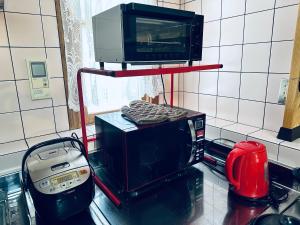 a microwave oven sitting on top of a kitchen counter at Shanshui House 箱館山 in Imazu