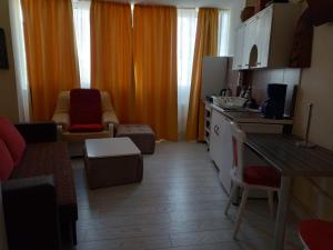 cocina con cortinas de color naranja y sala de estar. en Two Bedroom Apartment Farmec, en Cluj-Napoca