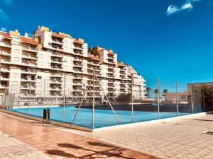 a large apartment building with a large swimming pool at Peñiscola playa in Peñíscola