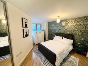 a bedroom with a bed and a mirror at 2 Bedroom Apartment near Olympic Park with Free Parking in London