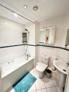 y baño con bañera, aseo y lavamanos. en 2 Bedroom Apartment near Olympic Park with Free Parking, en Londres