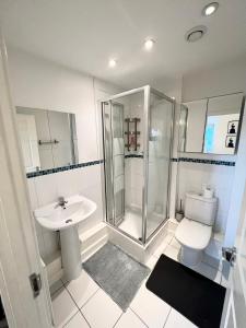 y baño con ducha, aseo y lavamanos. en 2 Bedroom Apartment near Olympic Park with Free Parking en Londres