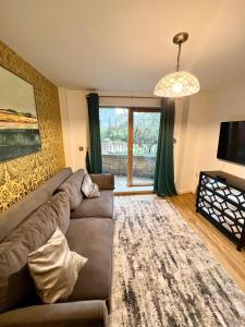 a living room with a couch and a large window at 2 Bedroom Apartment near Olympic Park with Free Parking in London