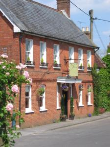 a red brick house with white windows and flowers at La Fosse at Cranborne in Cranborne