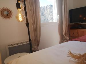 een lamp in een slaapkamer met een bed en een raam bij T2 tout neuf avec Parking à 10km d'Aix et Marseille in Septèmes-les-Vallons