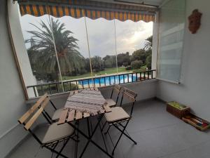 a balcony with a table and chairs and a large window at Apartment with pool near the beach in Marbella