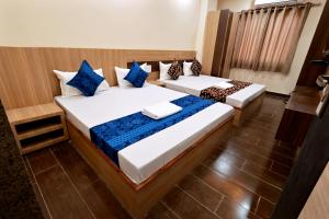 2 Betten in einem blau-weißen Zimmer in der Unterkunft HOTEL ROYAL SUITES + in Ajmer