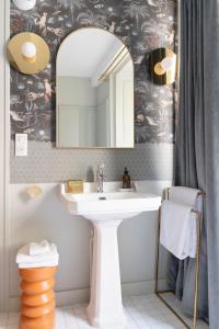 W łazience znajduje się umywalka i lustro. w obiekcie Séjours Maison Baluchon w mieście Chaumont