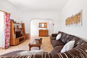 - un salon avec un canapé et une table dans l'établissement Casa da Bia by OCvillas, à Albufeira